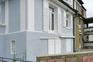 sanierte Fassade mit Klappladen und Schiebeladen